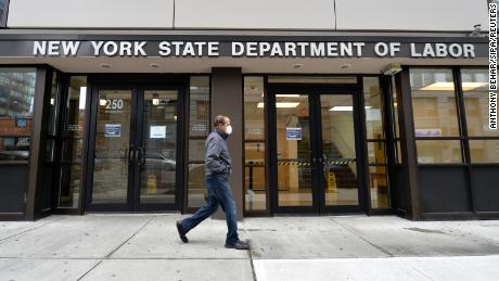 Surge in US unemployment claims cuases Governemnt servers to crash. A man wearing a protective mask walks past the New York State Department of Labor offices in the New York City borough of Brooklyn, NY, March 25, 2020. Anthony Behar/Sipa/Reuters